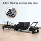Black exercise reformer with 2.8mm thick aluminum alloy frame on a light wooden floor.