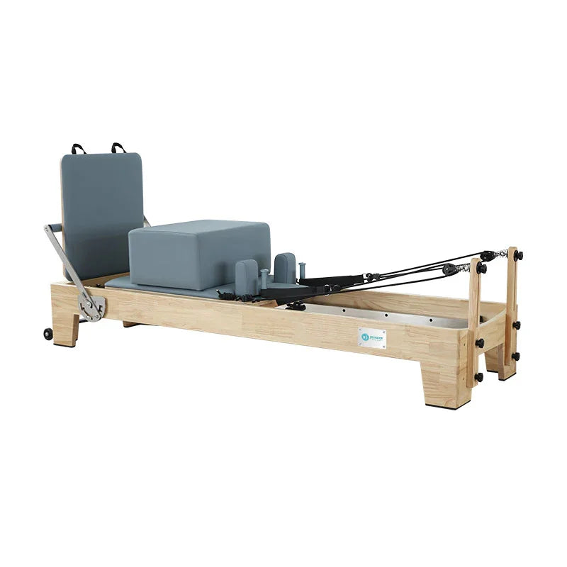 Joyrider Pilates reformer machine with wooden base and gray cushioned cover.